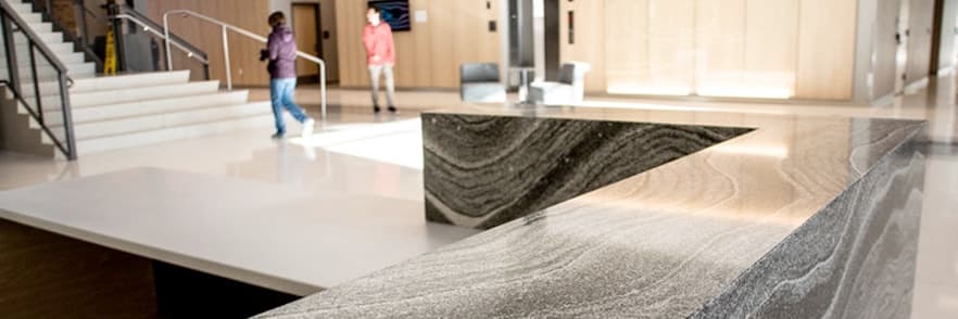 Commercial lobby with a long reception counter in swirled gray stone