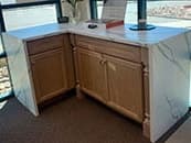 Wood vanity with a white solid-surface waterfall top